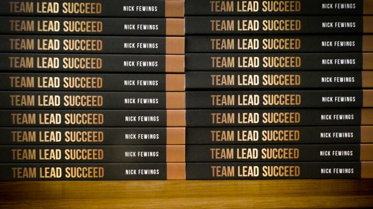 Uma Pilha De Livros Sentados Em Cima De Uma Mesa De Madeira BbVUxPwQiDM