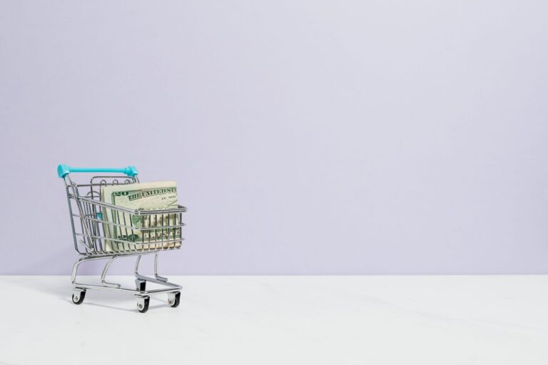 Shopping cart filled with cash on a plain background, ideal for finance and retail themes.