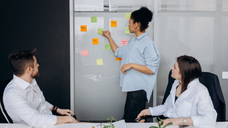 Business team collaborating and brainstorming in a meeting room with sticky notes.