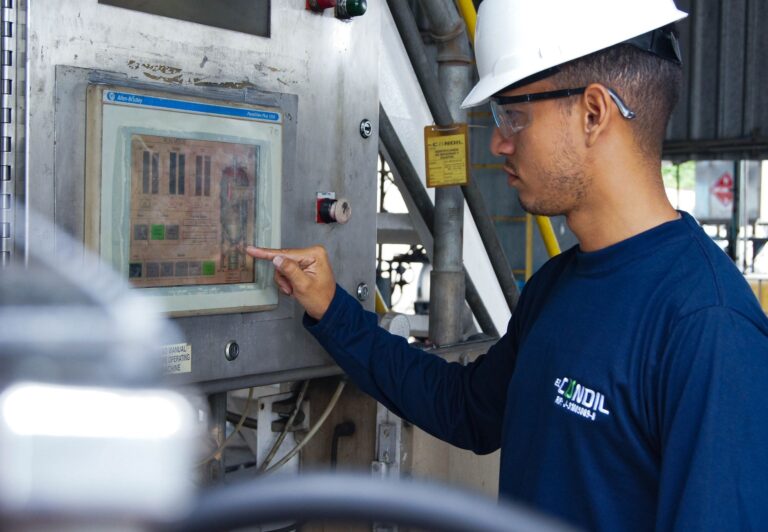 Engineer using control panel at industrial facility, ensuring operational efficiency.